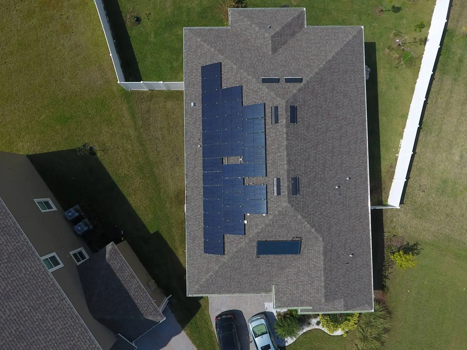 Top-down aerial view of a home with solar panels on a grey shingle roof