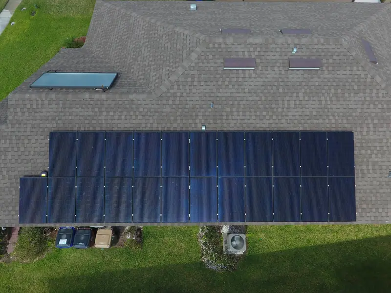 A long row of solar panels on a roof seen from directly above